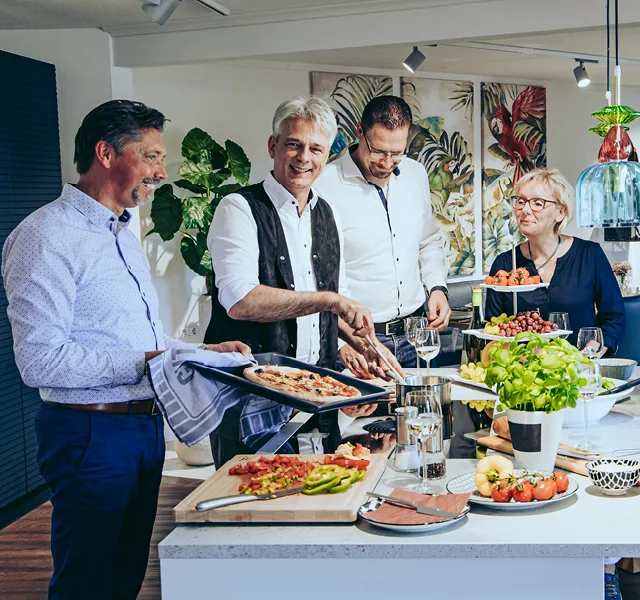 Das Himmlisch-Wohnen Team in der Küche beim anrichten von selbst gebackener Pizza und Beilagen
